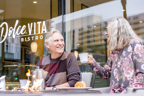 Lifestyle photography of senior couple dining at bistro in Tempe, AZ. High-end senior living media by Keynote Creative
